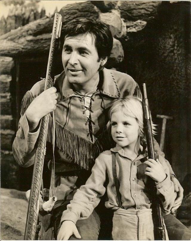 A warm moment between Fess Parker and a young actor, showcasing their strong on-screen relationship in Daniel Boone.